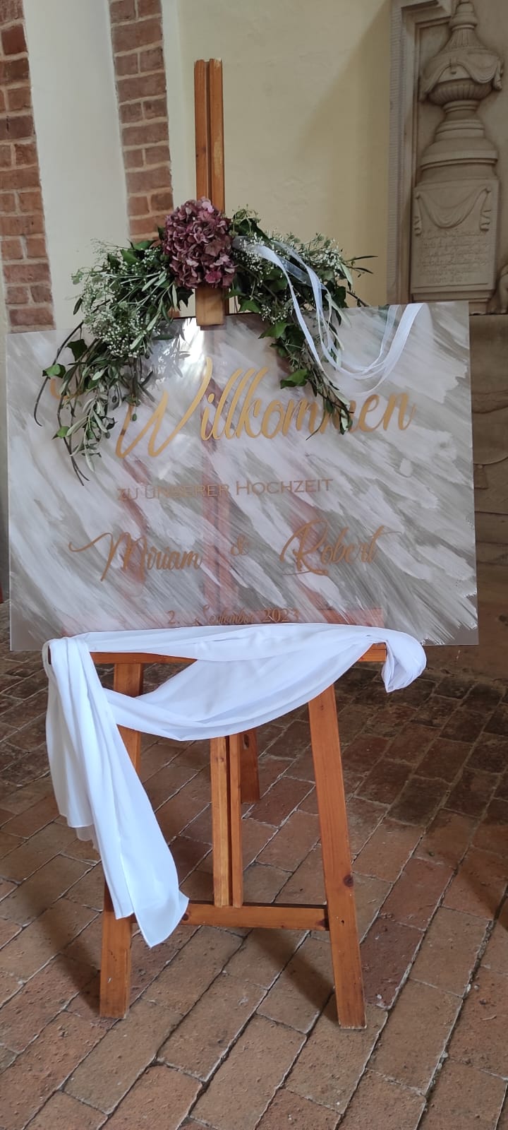 Transparentes Willkommensschild für eine Hochzeit auf einer Staffelei